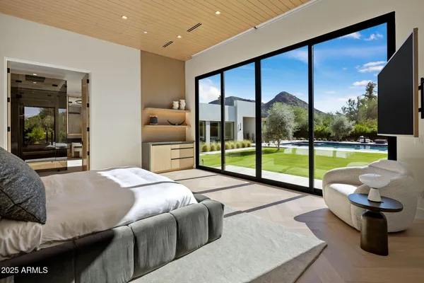 a large living room with a large window and chandelier