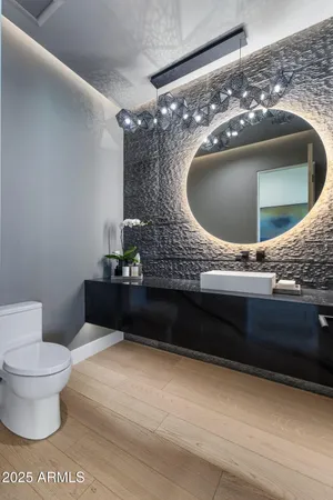 a bathroom with a granite countertop sink and a toilet