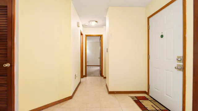 an empty room with windows and chandelier fan