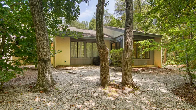 a view of a house with backyard and trees