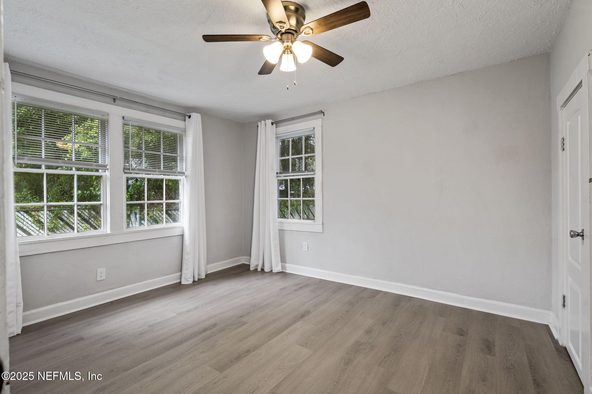 3910 Grant Road Jacksonville, FL 32207 - Photo 21 of 36 a view of an empty room with a window and wooden floor