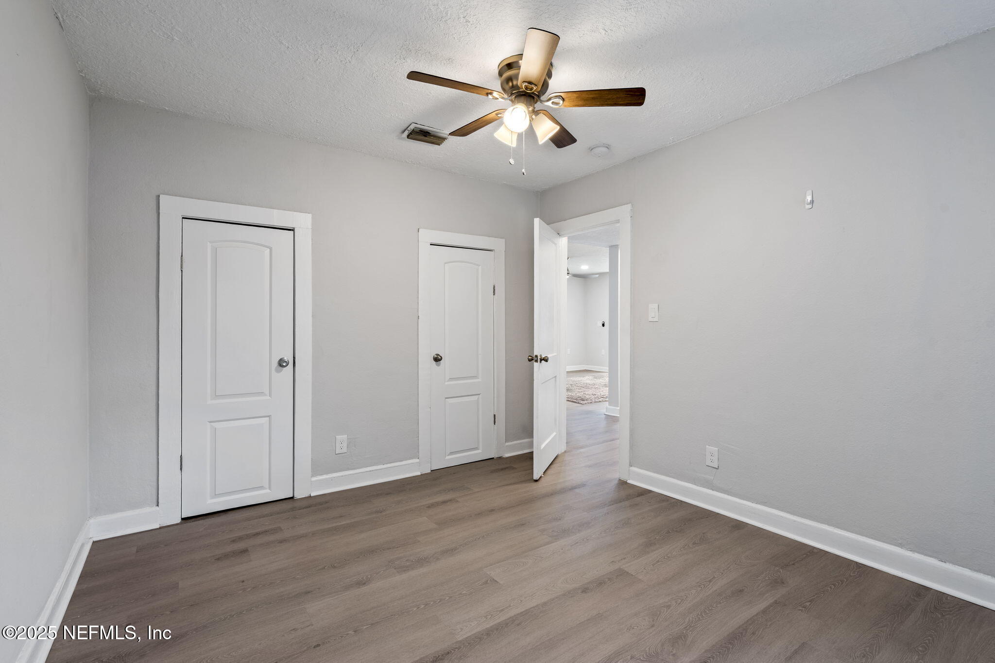 3910 Grant Road Jacksonville, FL 32207 - Photo 22 of 36 an empty room with wooden floor and ceiling fan