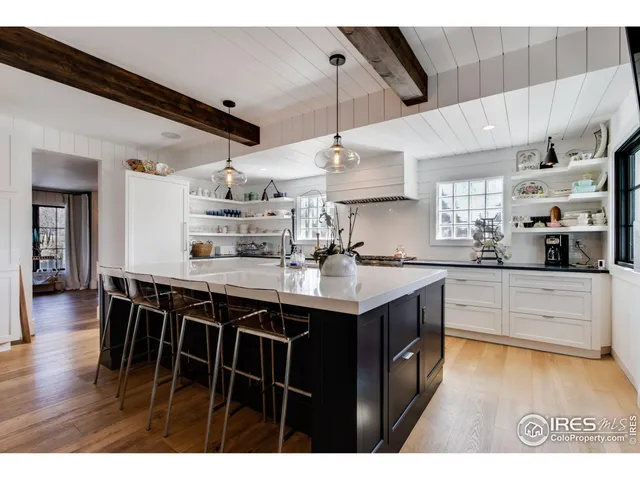 a kitchen with stainless steel appliances granite countertop a sink a stove and chairs