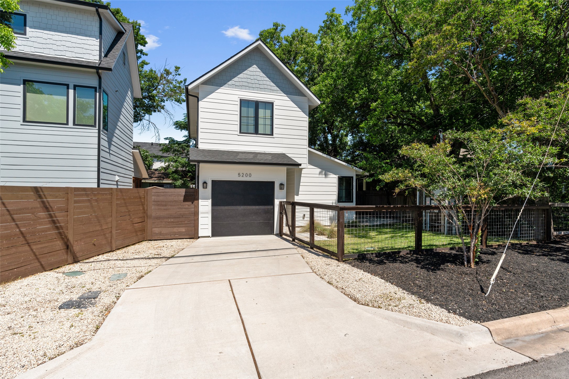 5200 Grover Avenue Austin, TX 78756 - Photo 2 of 32 Contemporary two-story residence featuring light siding and a dark garage door. Fully fenced front yard.