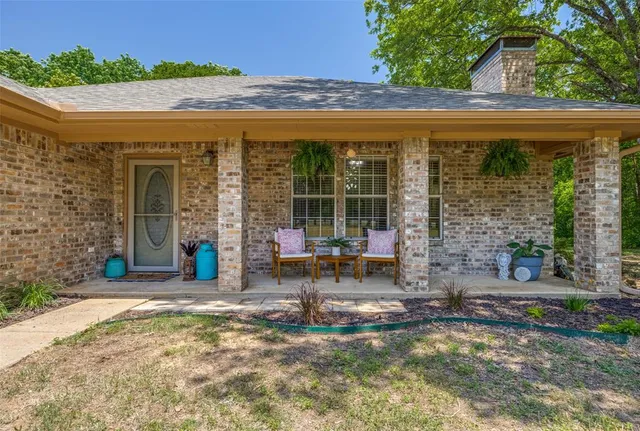 a view of a patio with table and chairs near a yard