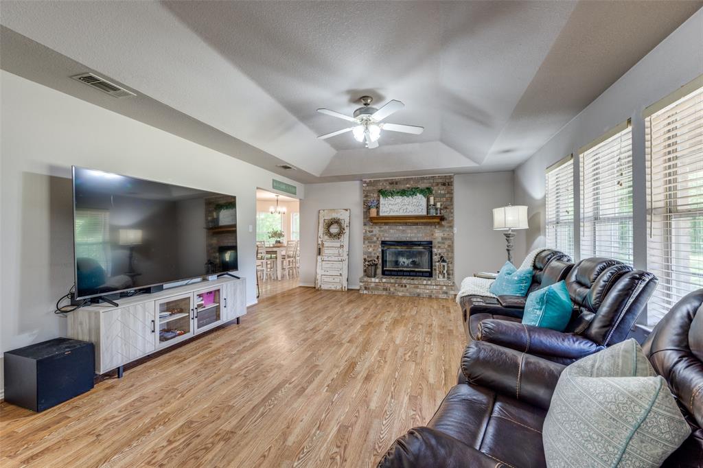 4942 Highway 69 Denison, TX 75021 - Photo 9 of 27 Living room with fireplace, wood floors, ceiling fan and windows overlooking your beautiful front yard.