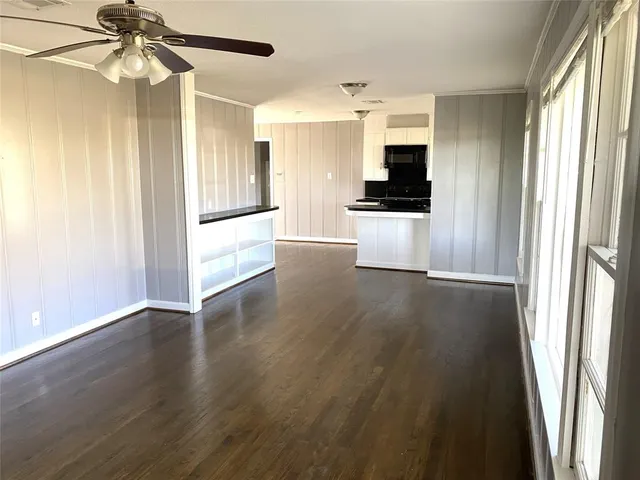 a view of a hallway with wooden floor and a living room