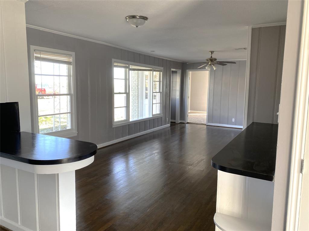 704 Scurlock Street Grandview, TX 76050 - Photo 4 of 11 a living room with wooden floor and a chandelier