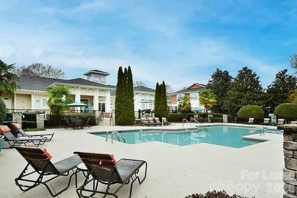 a view of a house with swimming pool and sitting area
