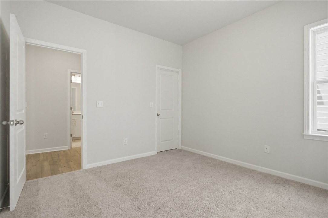 557 Hydrangea Street, Unit LOT 46 Seneca, SC 29678 - Photo 16 of 37 A spacious bedroom featuring plush carpeting and natural illumination from a large window.