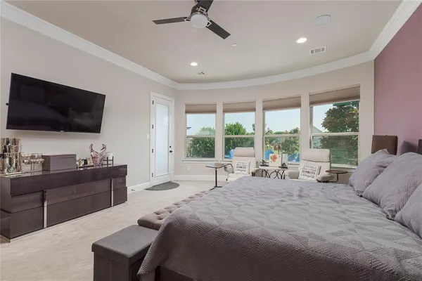 a spacious bedroom with a large bed and a flat screen tv