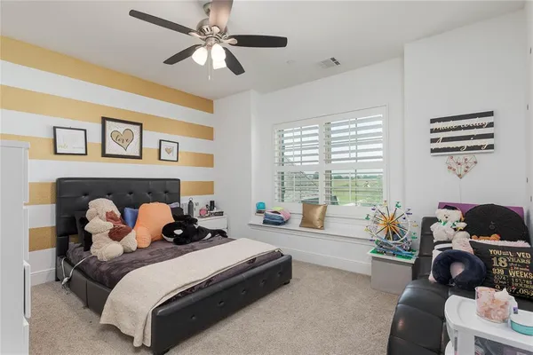a bedroom with a bed a couch and a window