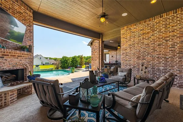 a group of chairs sitting in patio with a fireplace
