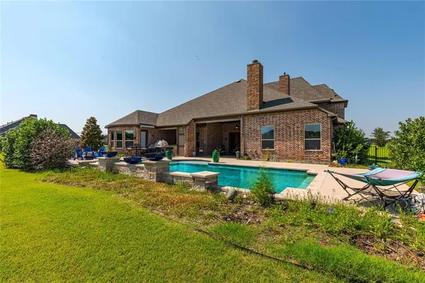 a front view of a house with swimming pool having outdoor seating
