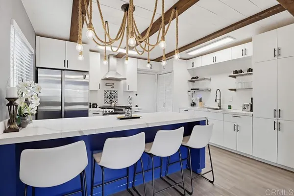 a kitchen with stainless steel appliances a dining table chairs and wooden floor