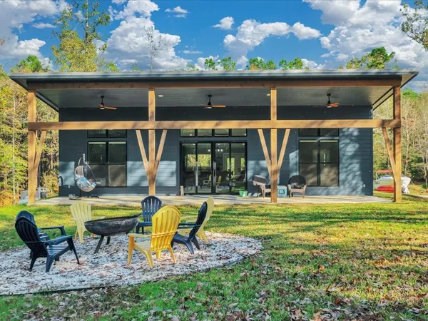 a view of a house with backyard outdoor seating area and furniture