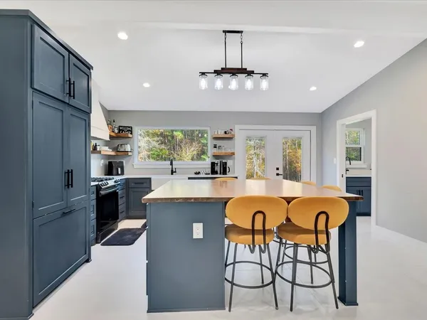 a large kitchen with a chandelier stainless steel appliances cabinets and a counter top space
