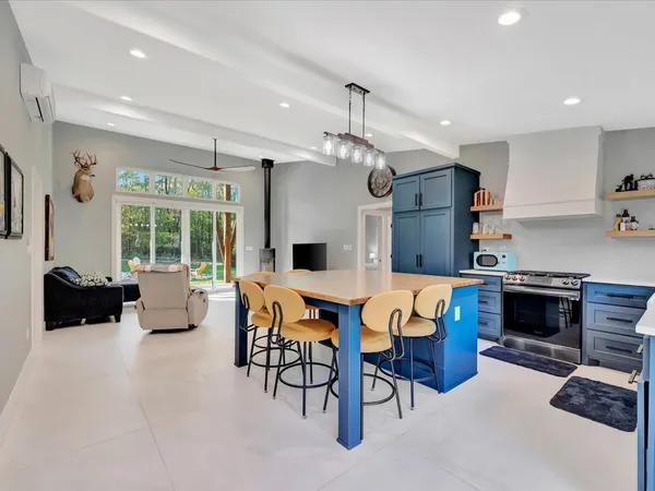 a kitchen with stainless steel appliances kitchen island granite countertop a table and chairs in it