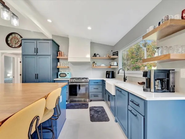 a large kitchen with stainless steel appliances granite countertop a stove and a sink