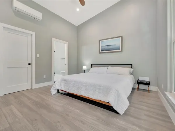 a bedroom with a bed and wooden floor