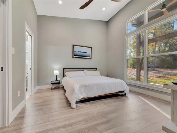 a spacious bedroom with a bed and a large window