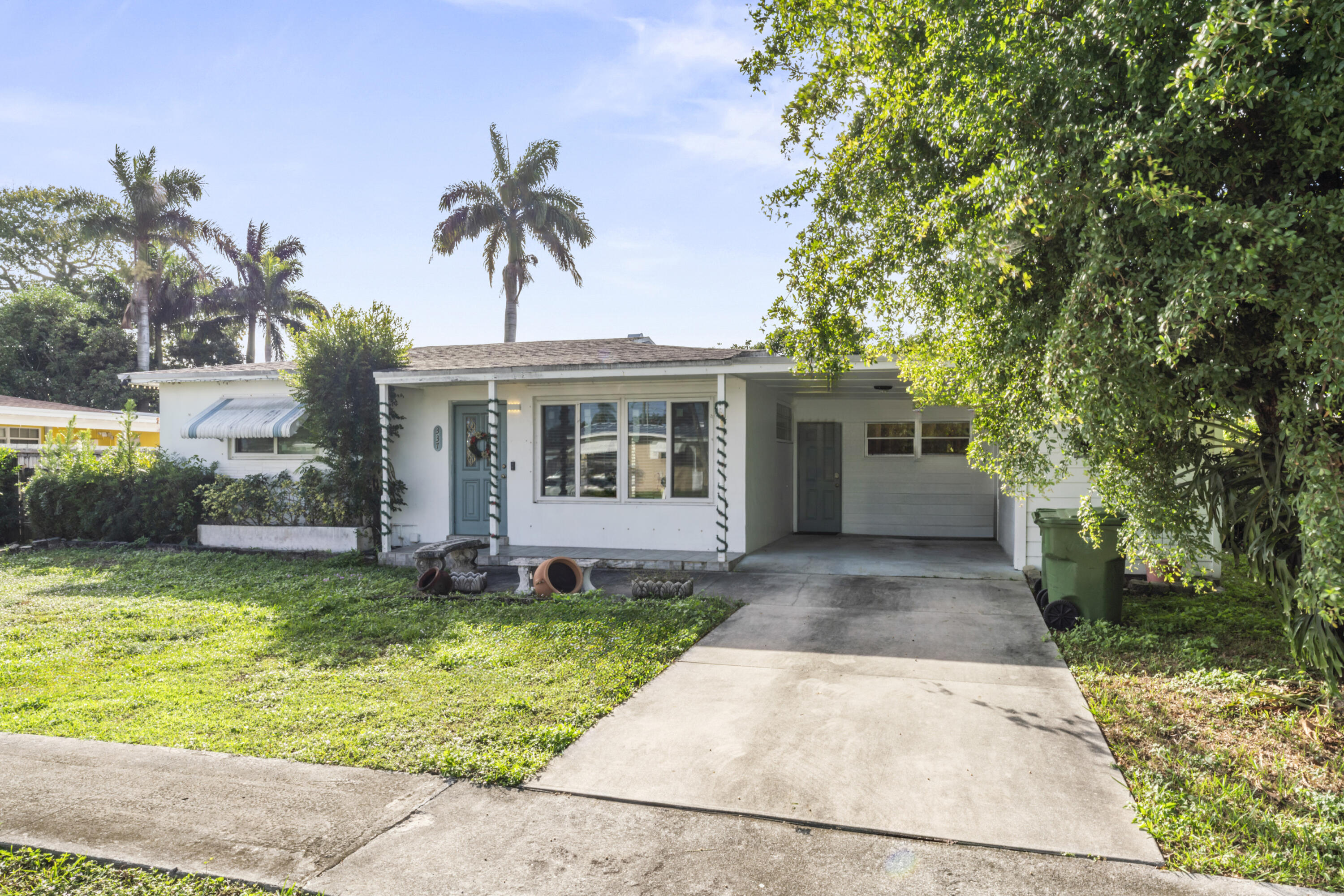 337 East Lake Road Palm Springs, FL 33461 - Photo 24 of 26 a view of a house with a yard and potted plants