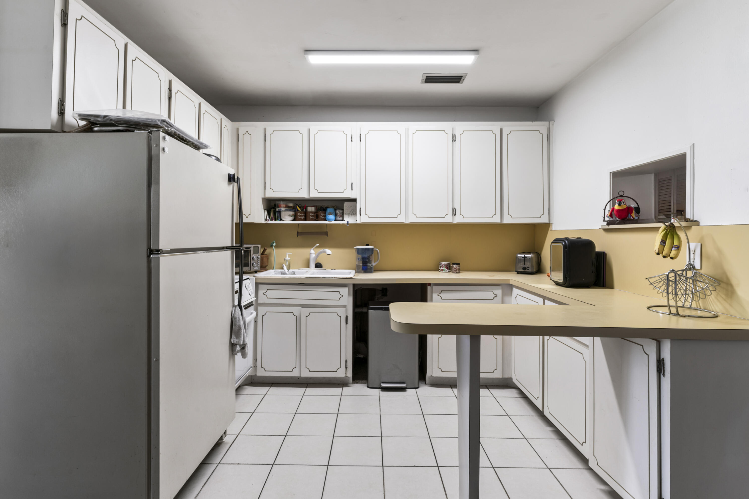 337 East Lake Road Palm Springs, FL 33461 - Photo 3 of 26 a kitchen with a refrigerator and white cabinets