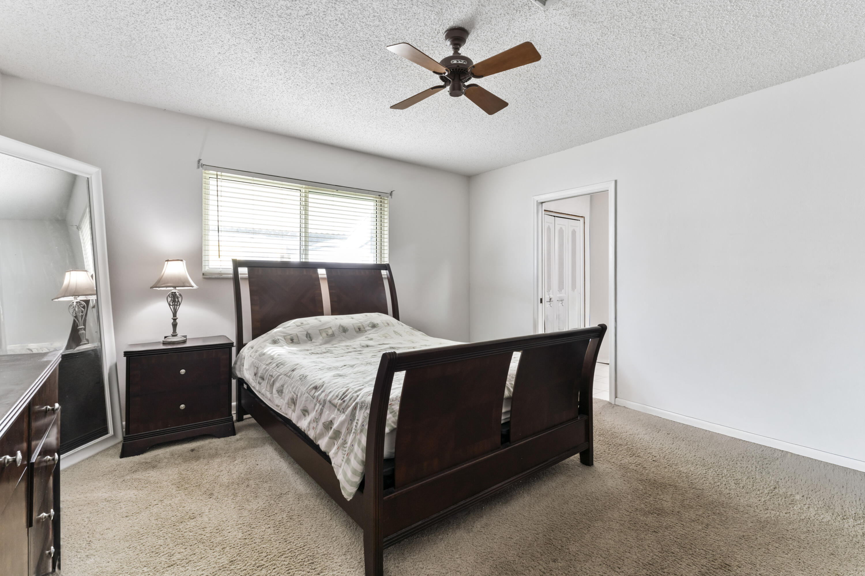 337 East Lake Road Palm Springs, FL 33461 - Photo 8 of 26 a bed sitting in a bedroom next to a window