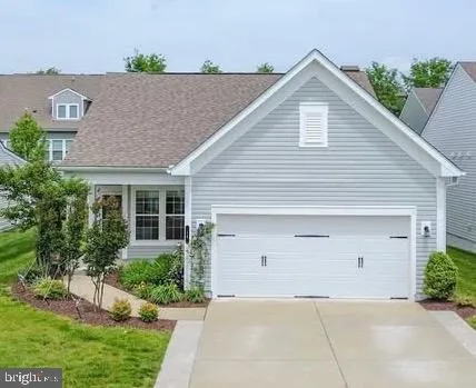 a front view of house with yard and trees in the background