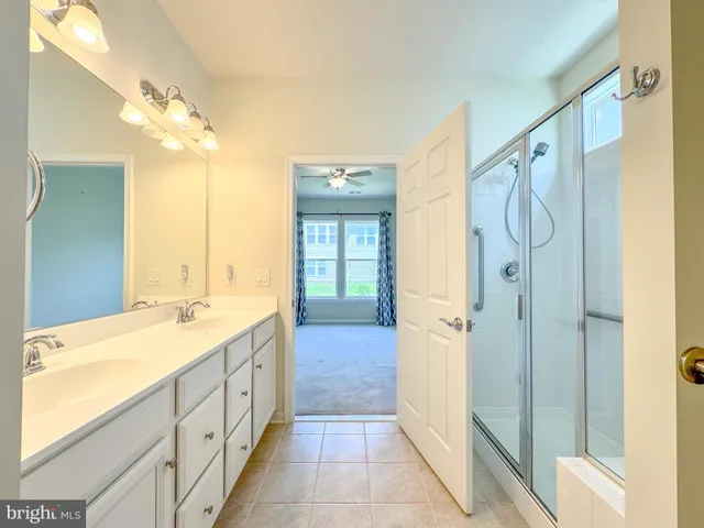 a bathroom with a double vanity sink mirror and shower