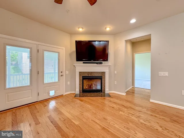a view of a livingroom with a fireplace wooden shelves and windows