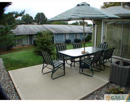 272 B Convent Road Monroe Township, NJ 08831 - Photo 10 of 10 a view of patio with a table and chairs under an umbrella