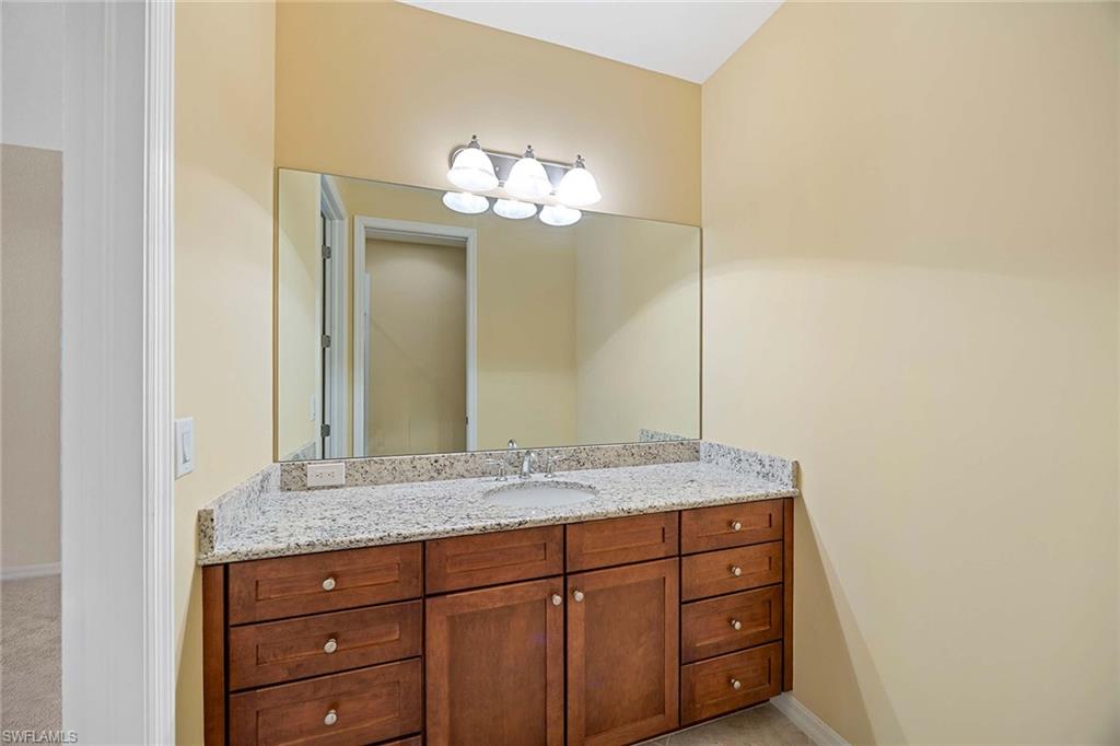 9036 Alturas Street, Unit 3603 Naples, FL 34113 - Photo 18 of 41 a bathroom with a granite countertop sink and a mirror
