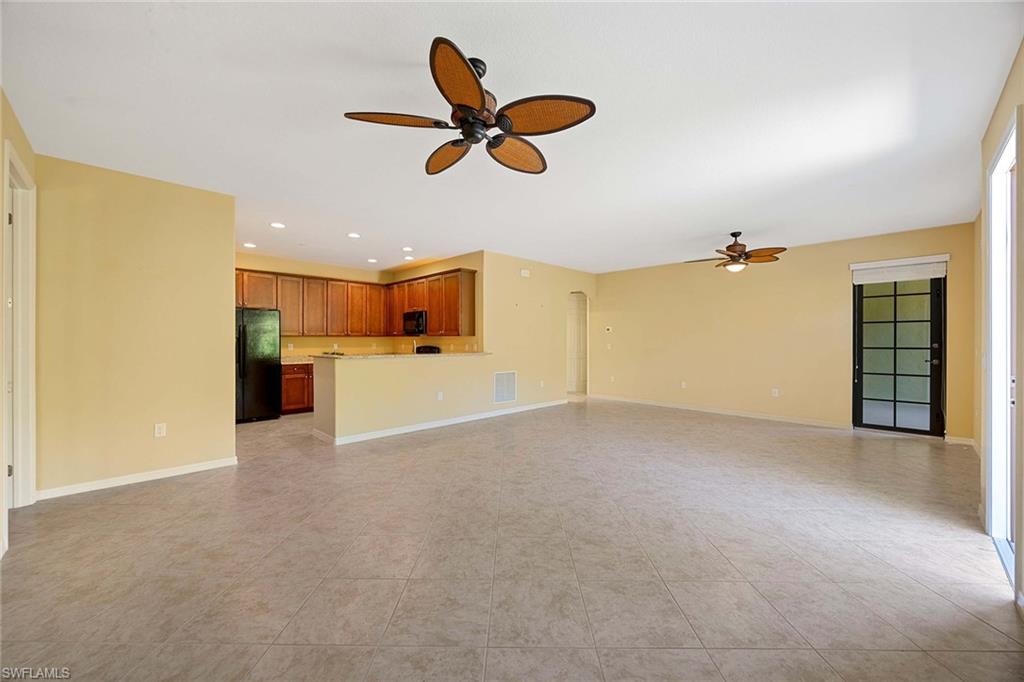 9036 Alturas Street, Unit 3603 Naples, FL 34113 - Photo 5 of 41 a view of a livingroom with a ceiling fan & kitchen space