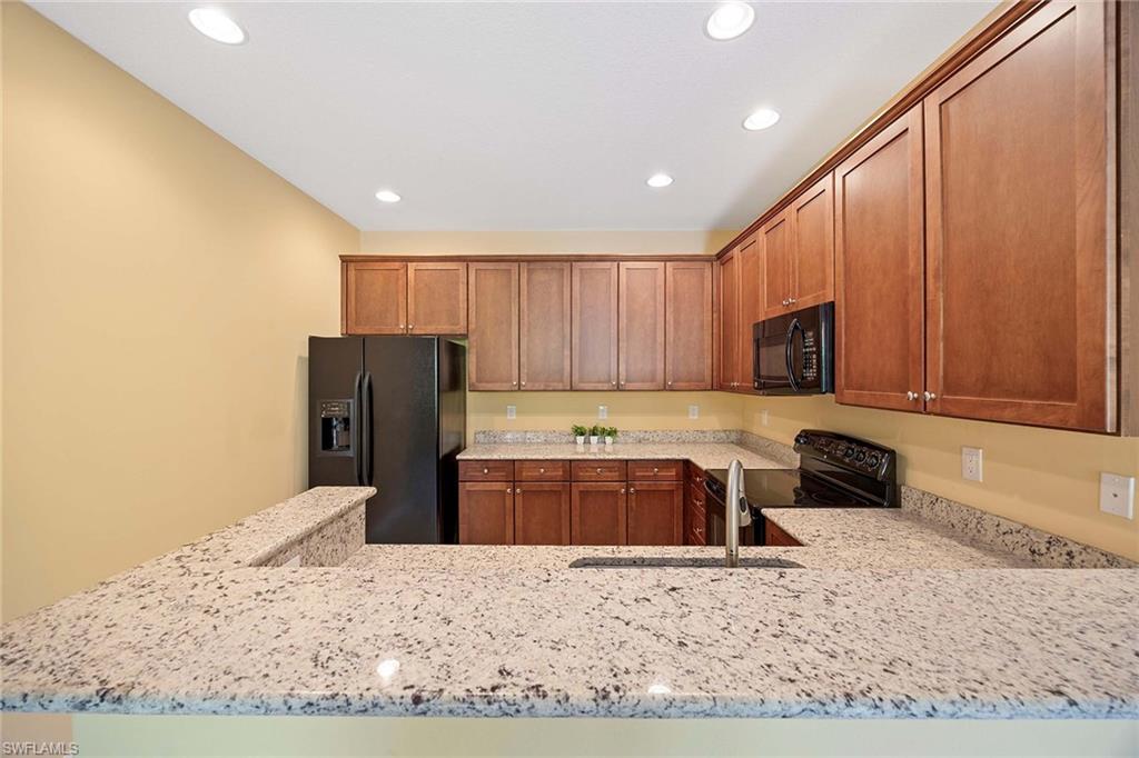 9036 Alturas Street, Unit 3603 Naples, FL 34113 - Photo 9 of 41 a kitchen with stainless steel appliances granite countertop a refrigerator a stove a sink and a microwave