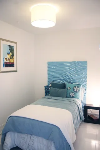a bedroom with a bed and a painting on the wall