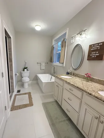 a bathroom with a granite countertop double vanity sink and a mirror