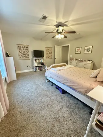 a spacious bedroom with a bed and a chandelier