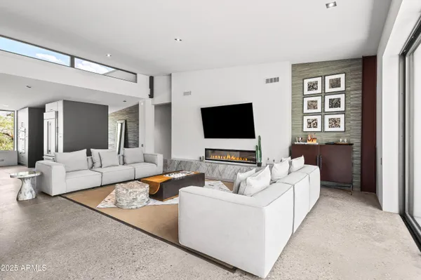 a living room with furniture large window and a chandelier