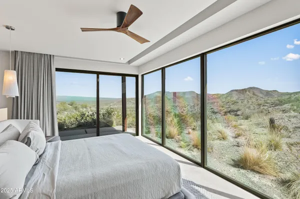 a bed sitting in a bedroom next to a large window