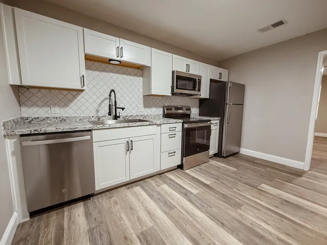 a kitchen with stainless steel appliances granite countertop a stove sink and microwave