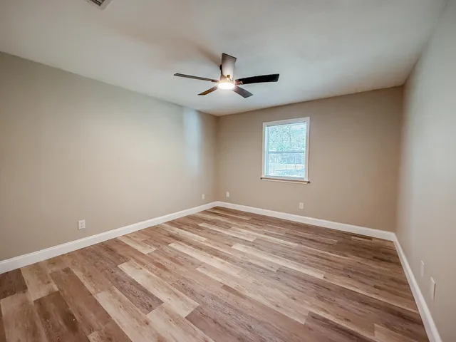 wooden floor in an empty room with a window