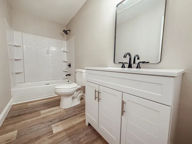 a bathroom with a toilet sink and mirror