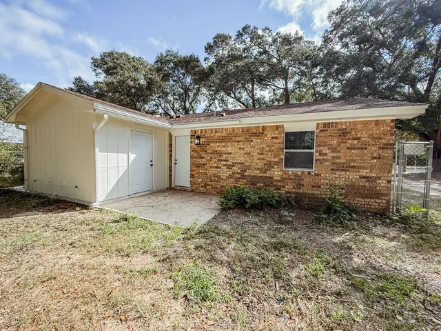 a backyard of a house with lots of plants and trees