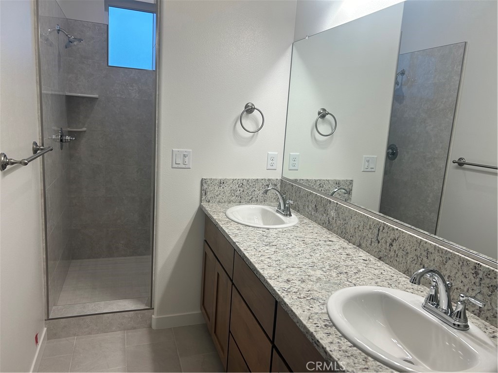 352 Gladstone Chico, CA 95973 - Photo 16 of 22 a bathroom with a granite countertop sink a mirror and shower