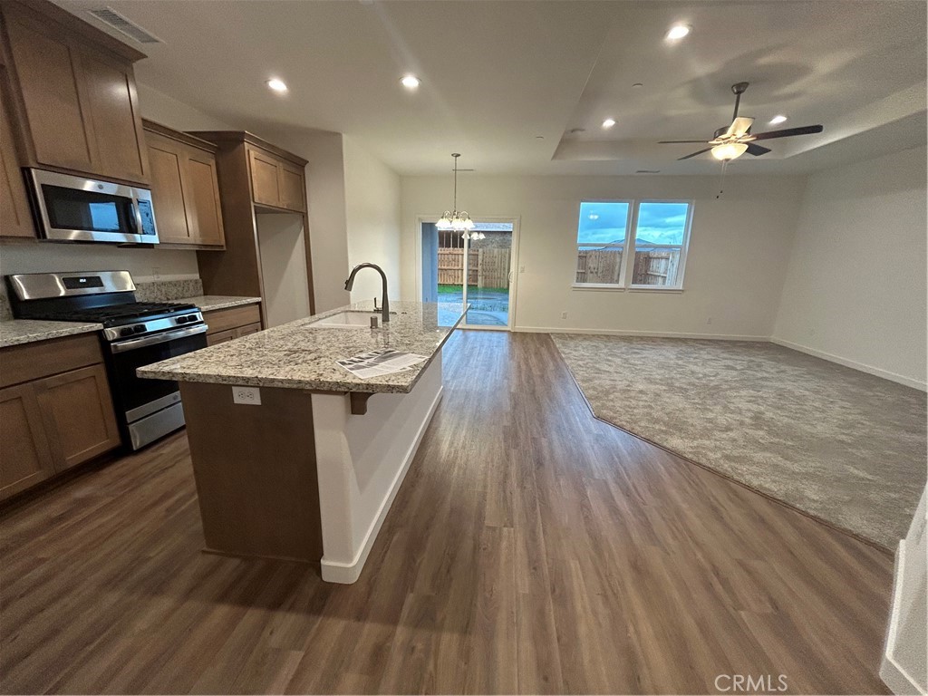 352 Gladstone Chico, CA 95973 - Photo 8 of 22 a kitchen with stainless steel appliances granite countertop a stove a sink dishwasher and a microwave oven with wooden floor