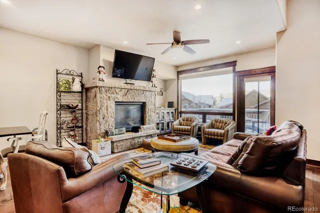 a living room with furniture fireplace and a large window