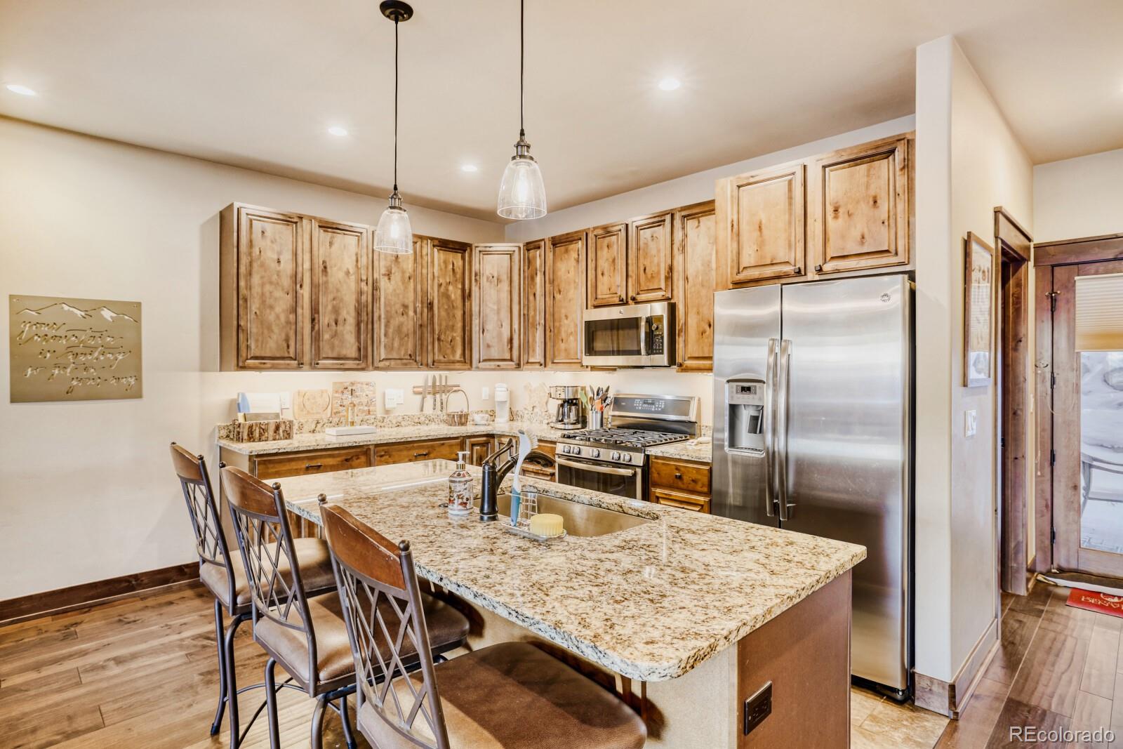 0852 Independence Road Dillon, CO 80435 - Photo 16 of 43 a kitchen with granite countertop a table chairs stainless steel appliances and wooden floor