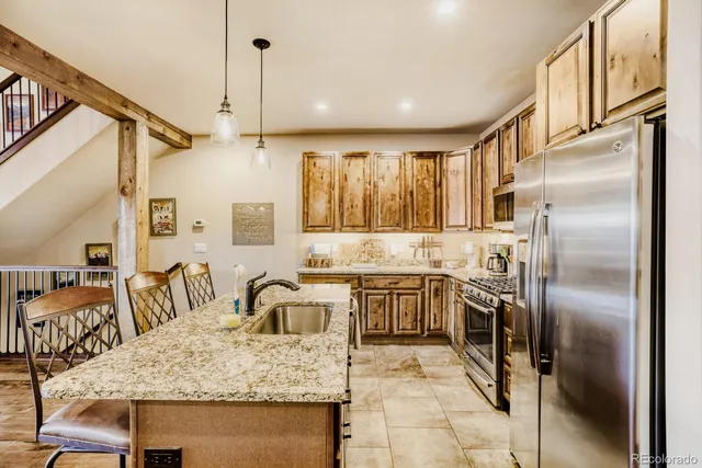 a kitchen with stainless steel appliances granite countertop a sink stove and refrigerator