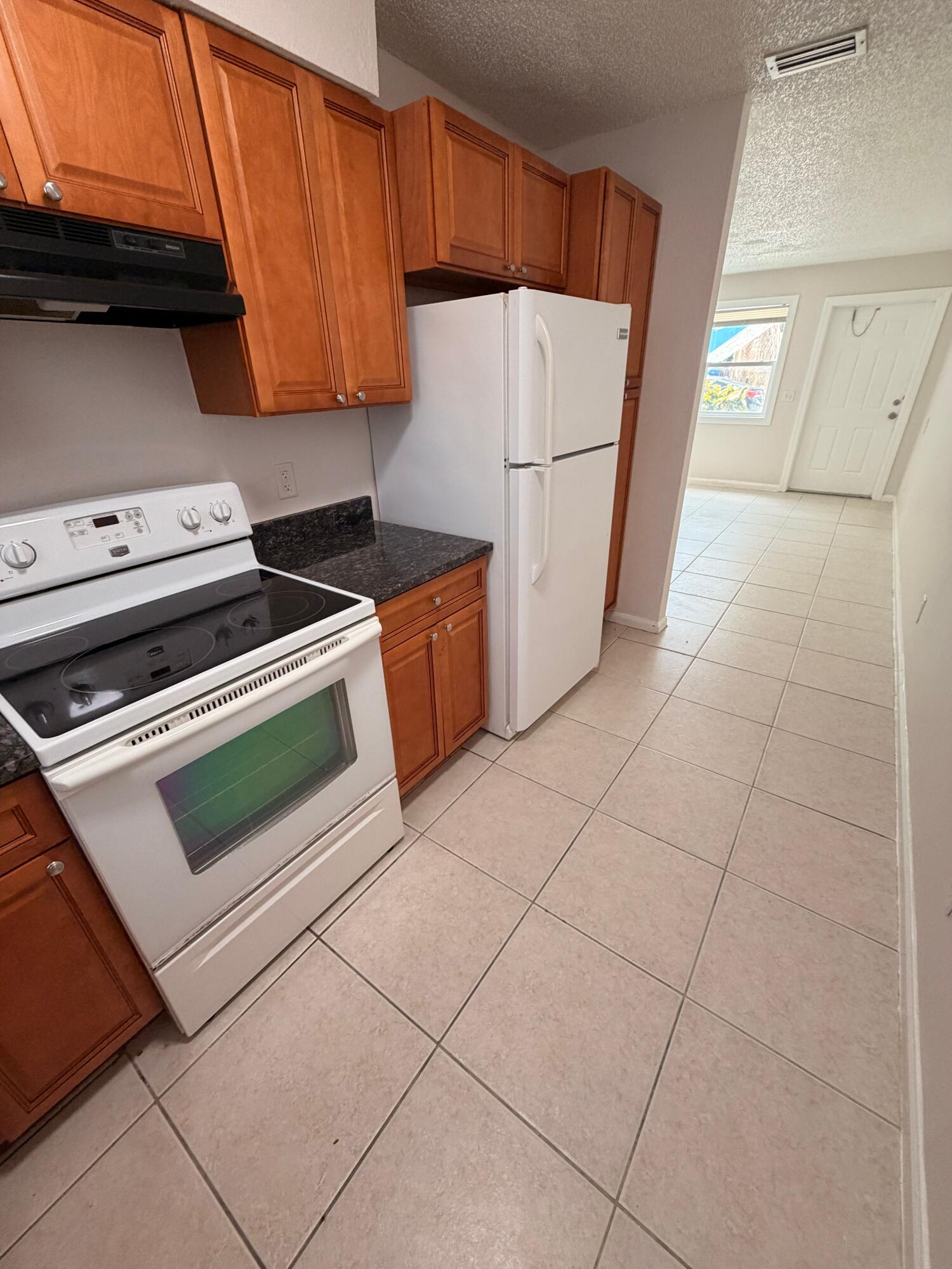 1618 West 26th Court, Unit A Riviera Beach, FL 33404 - Photo 4 of 15 a kitchen with a stove and a refrigerator